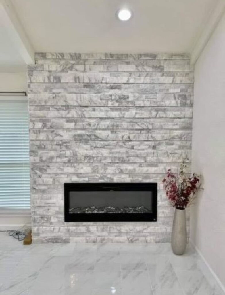 Stunning remodeled fireplace set against a white brick wall, expertly crafted by a top chimney and fireplace company in Fort Worth, Texas.