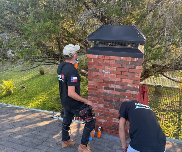 Chimney with a custom cap and red bricks in Fort Worth, Texas, repaired and rebuilt for durability.