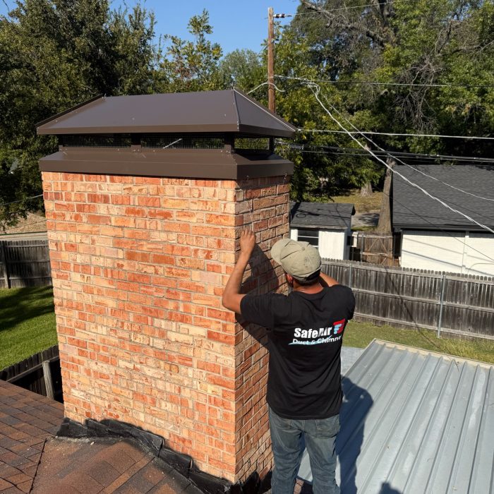 Custom chimney cap on a red brick chimney in Dallas, Texas, enhancing protection and durability.