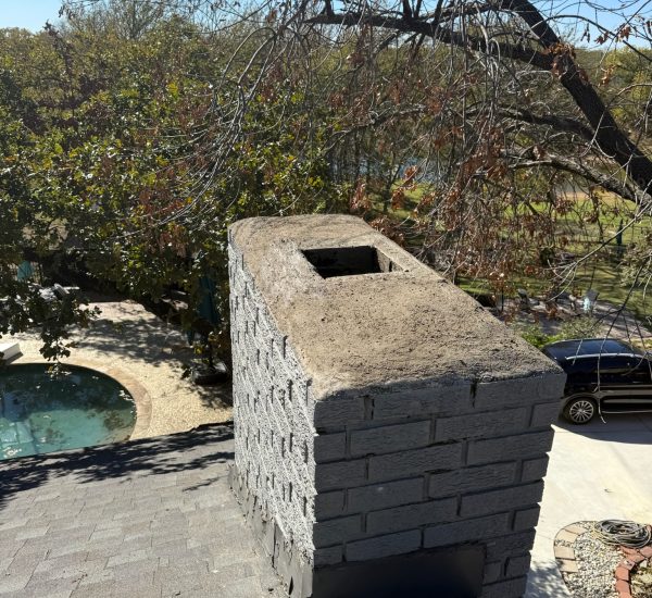 Chimney crown repair on a gray brick chimney in Irving, Texas, ensuring durability and safety.