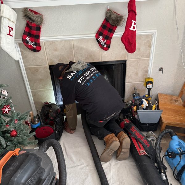 Chimney and fireplace company cleaning and inspecting a gas fireplace in Frisco, Texas, for safety and efficiency.