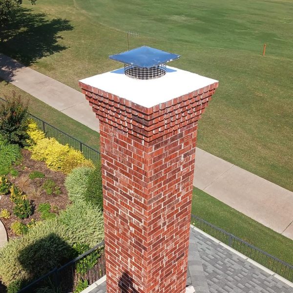 Chimney repair services for a red brick chimney with a cap in Fort Worth, Texas.