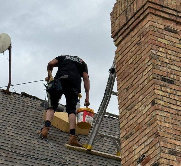 Chimney repair on a high roof in Dallas, Texas, ensuring safety and durability.