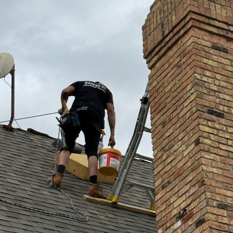 Chimney repair on a high roof in Dallas, Texas, ensuring safety and durability.