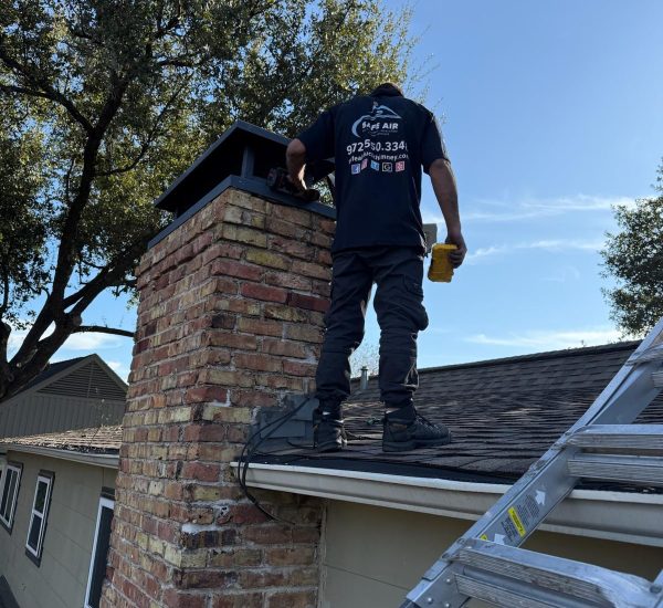 Chimney repair on a roof with red bricks in Dallas, Texas, restoring safety and functionality.